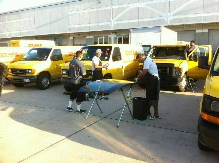 Our team of five technicians are captured in this image, diligently working on replacing damaged front windshields of a DHL Express Shipping fleet. The company vans, stationed in a spacious parking lot, encountered damage from road debris during delivery runs. Each windshield required a full replacement. The photo, taken in Highland Hills, Texas, illustrates our capabilities in handling commercial auto glass appointments for corporate fleets.