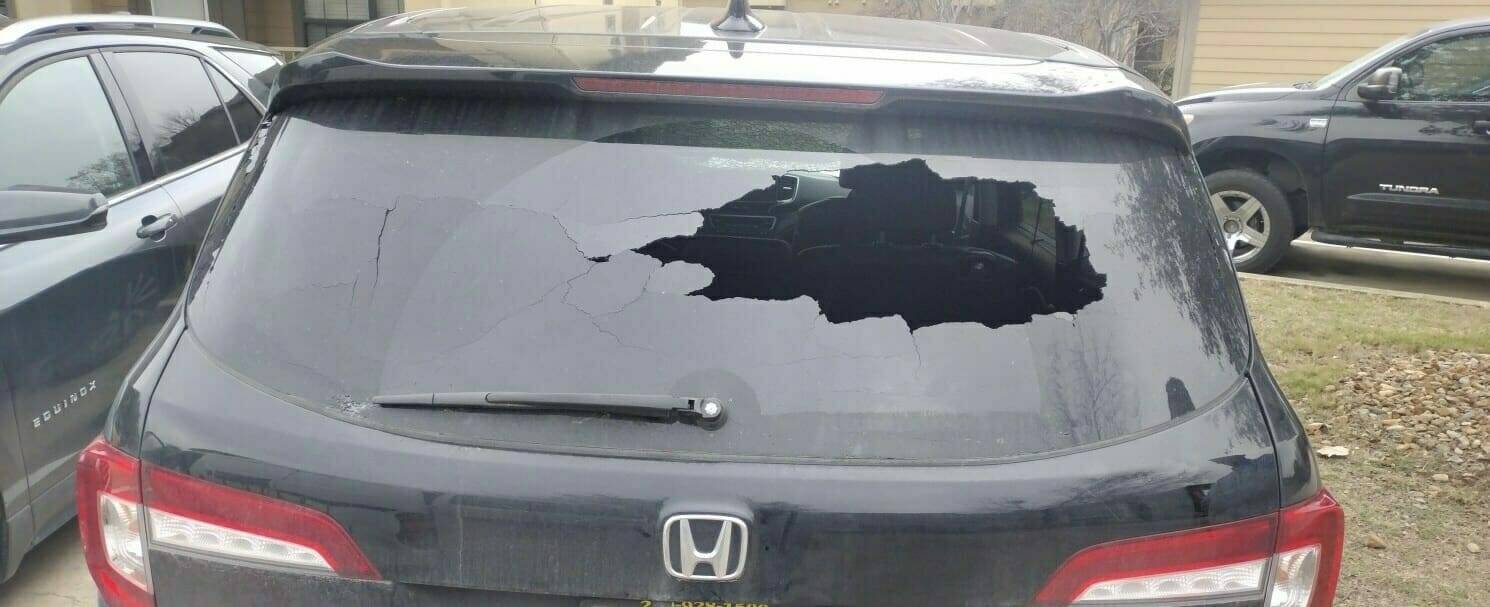 The displayed image shows a 2018 Honda Pilot SUV located in Converse, Texas. Its rear windshield is significantly damaged due to an accident and is in a state of total disarray, thus requiring a complete replacement. The rear windshield initially featured factory privacy tint. Our professional home auto glass services were summoned to restore the vehicle's safety and aesthetics.