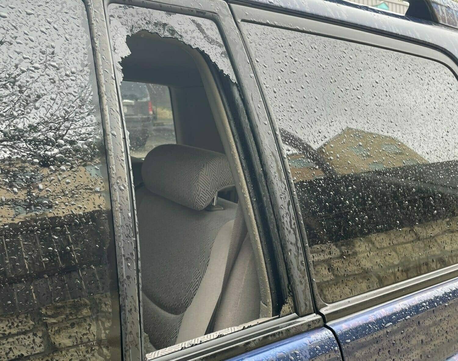 This image features a 2015 Nissan Pathfinder SUV situated in Helotes, Texas. The left rear driver's side vent glass has been severely damaged as a result of a robbery, necessitating a complete replacement. Originally, the quarter glass had factory privacy tint. The vehicle is scheduled for a home auto glass replacement appointment to restore its integrity and privacy.