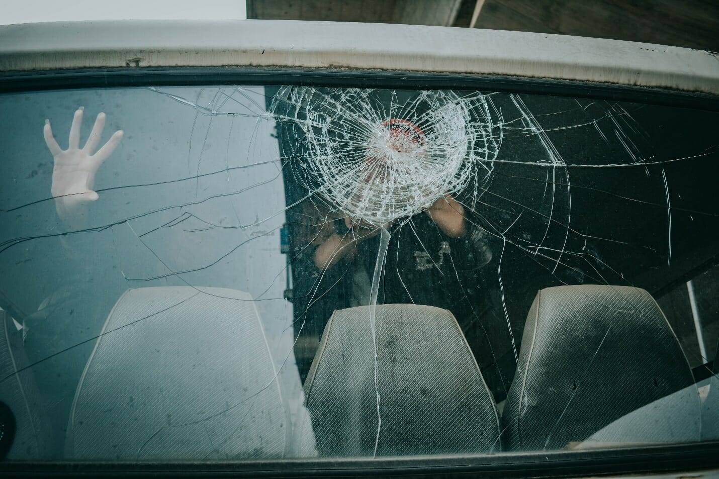 Person in a car with a broken windshield